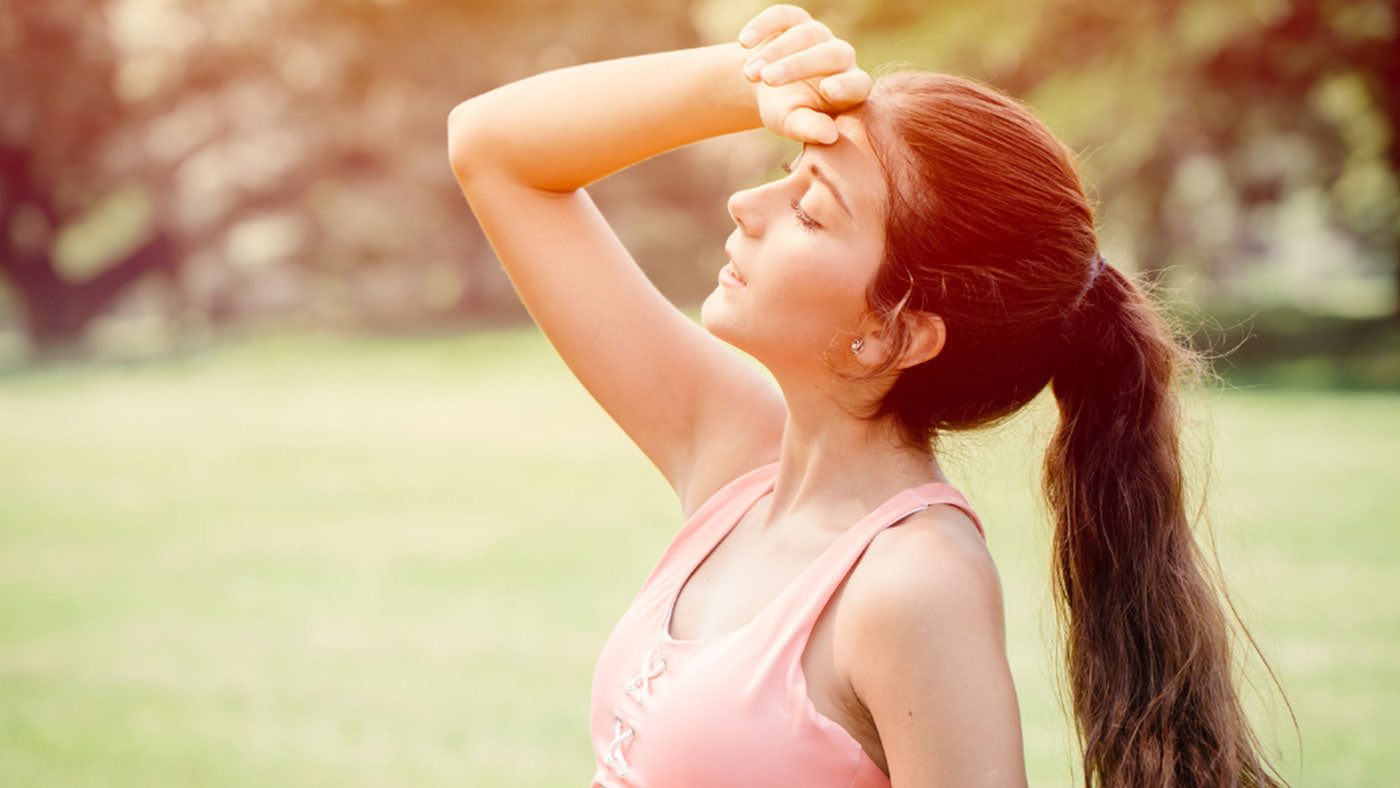 Woman sweating in Singapore's heat, a guide to skin temperature and aging skincare at Dear Glow